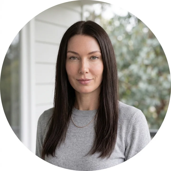 Round profile crop of Melanie Laas in a dove grey knit on a verandah with eucalypt behind